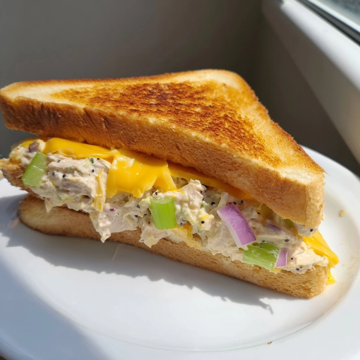 Golden-brown classic tuna melt sandwich with melted cheddar; a satisfying lunch!