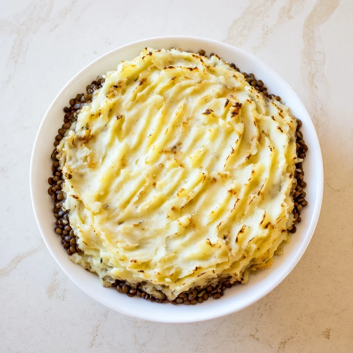 Hearty Lentil Shepherd's Pie: a warm, baked dish with creamy mashed potatoes over a savory lentil filling.