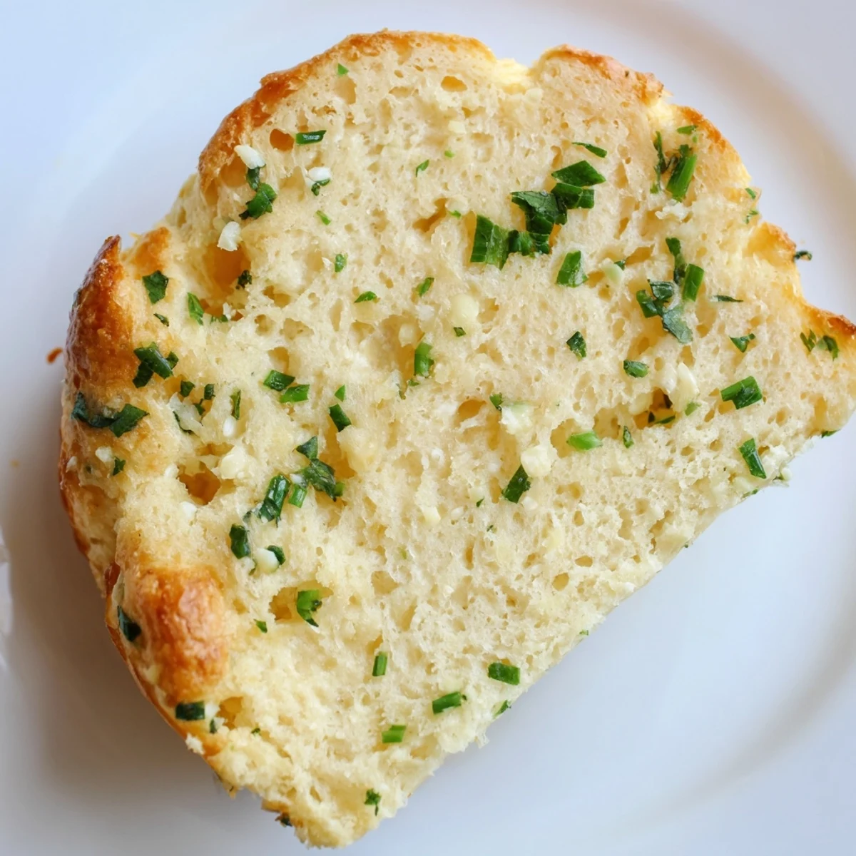 Golden-brown cloud bread savory toasts topped with fresh chives and parsley, arranged on a rustic wooden board.  
