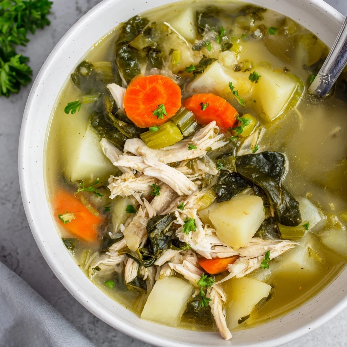 Collard Greens, Chicken and Vegetable Soup served hot in a ceramic bowl, with a lemon wedge and crusty bread on the side.