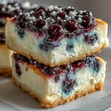 Close-up of no-bake lemon blueberry cheesecake bars featuring a vibrant berry swirl.
