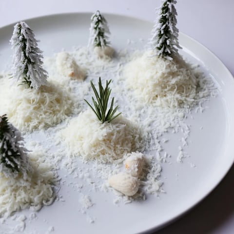 The artfully arranged Frosted Pine cheese board showcases fluffy white cheddar snowdrifts and sugared rosemary pines.
