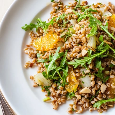 Farro salad with fennel, oranges, and almonds in a citrus vinaigrette, served in a white bowl.