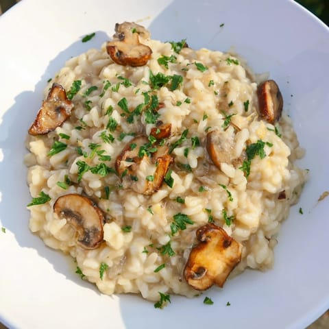 Steaming bowl of stove-top creamy risotto, a rich Italian rice dish with Parmesan and parsley.