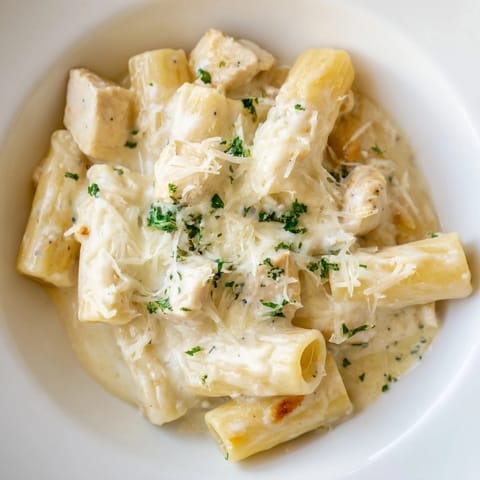 Tender chicken and pasta smothered in rich Alfredo, baked to perfection, a delicious Chicken Alfredo Bake.