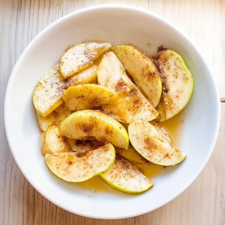 Warm, bubbling Baked Apple Slices ready to serve, a comforting, cinnamon-spiced dessert for autumn.