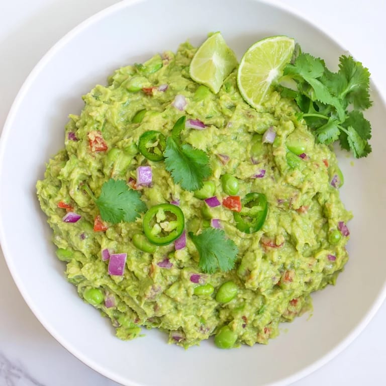Textured view of edamame guacamole, showing the creamy avocado and colorful cilantro garnish.