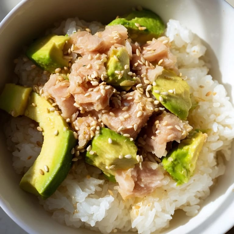 Nourishing Tuna Avocado Rice Bowl served warm, featuring fragrant jasmine rice, diced avocado, and a hint of sriracha for spice.