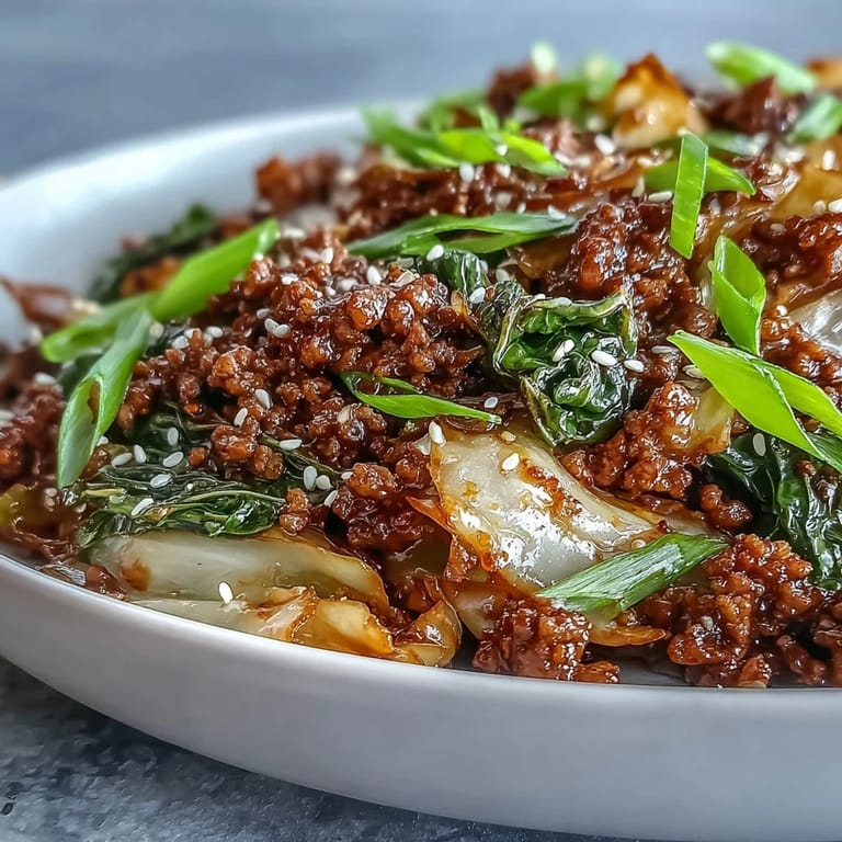 A hearty serving bowl of Chinese Ground Beef and Cabbage Stir-Fry alongside cauliflower rice, perfect for a low-carb weeknight dinner.
