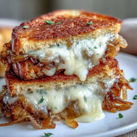 Golden French Onion Grilled Cheese with perfectly melted Gruyère and caramelized onions.